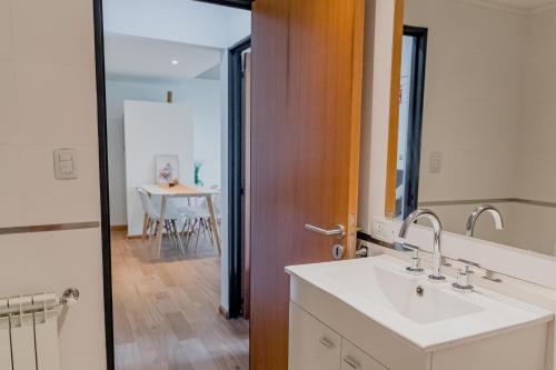 W łazience znajduje się umywalka, lustro i stół. w obiekcie Depto Genova, Zona Norte, Cochera disponible w mieście Rosario