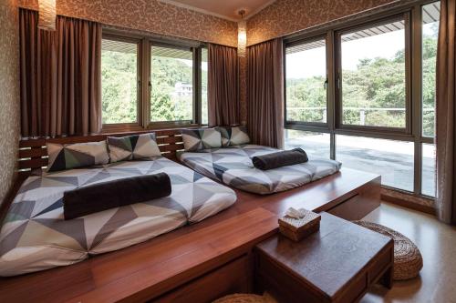 1 dormitorio con 2 camas, sofá y ventanas en 小鳥敲門 Bird Villa, en Shuangxi