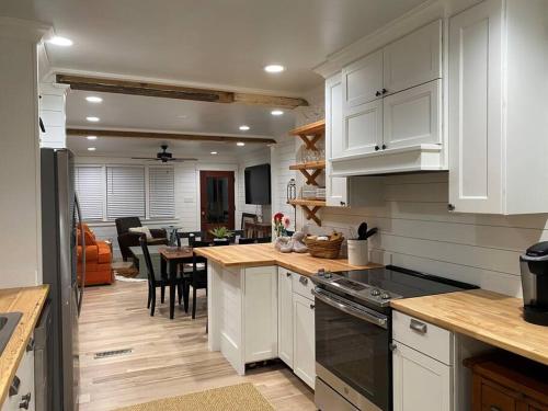 a kitchen with white cabinets and a dining room at Walk to Bay Street and Historic Downtown Beaufort! Close to Parris Island MCRD!! in Beaufort