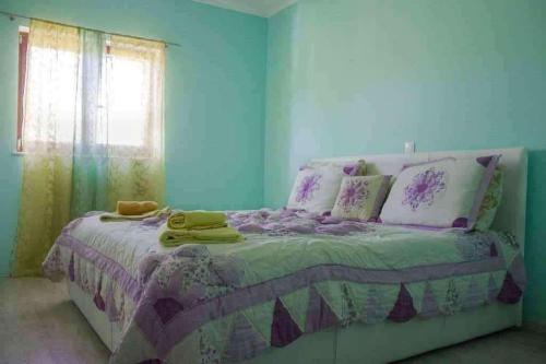 - une chambre avec un lit doté d'une couette violette et d'une fenêtre dans l'établissement Apartments with a parking space Zavalatica, Korcula - 9690, à Zavalatica