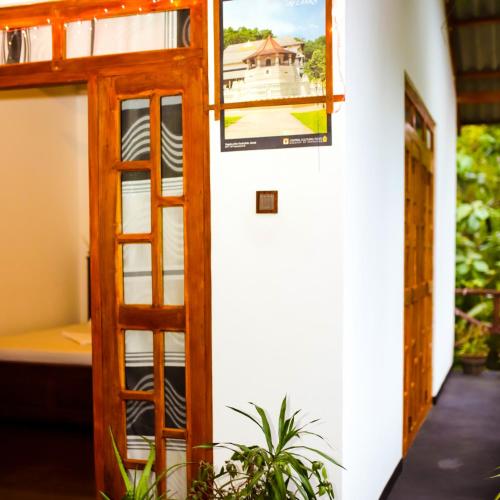 a room with a door and a poster of a house at Aloe Vera Guest House in Dambulla