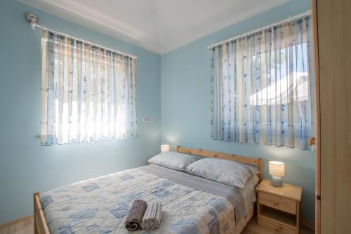 a bedroom with a bed with blue walls and windows at Holiday house with a parking space Kastel, Central Istria - Sredisnja Istra - 14572 in Buje