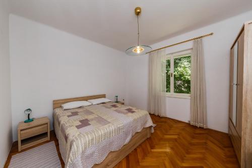 a bedroom with a bed and a window at Apartments by the sea Kastel Stari, Kastela - 14577 in Kaštela