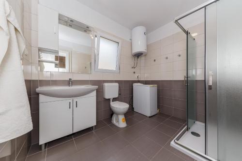 La salle de bains est pourvue de toilettes, d'un lavabo et d'une douche. dans l'établissement Apartments by the sea Kastel Stari, Kastela - 14577, à Kaštela