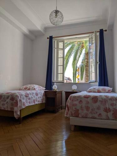 une chambre avec deux lits et une fenêtre dans l'établissement Amazing 2-bedroom apartment in Nice near the beach, à Nice