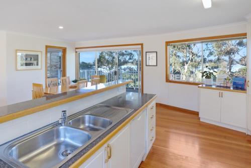 a kitchen with a sink and two windows at LAKESIDE2 in Merimbula
