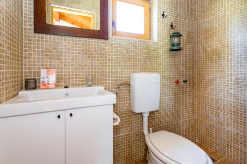 a bathroom with a toilet and a sink and a mirror at Secluded holiday house Milovcici, Krk - 14604 in Malinska