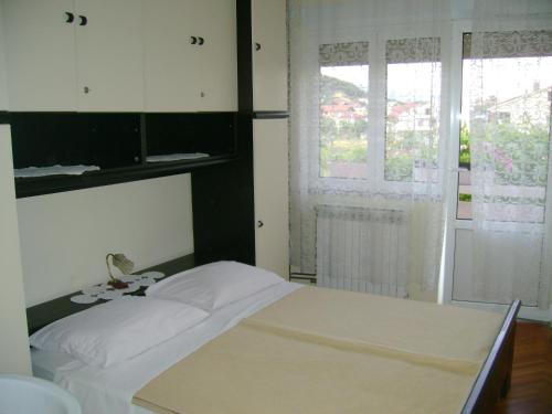- une chambre avec un lit blanc et 2 fenêtres dans l'établissement Apartments with a parking space Palit, Rab - 14610, à Rab