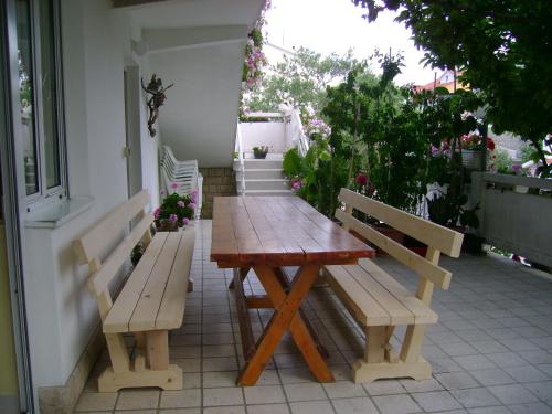 une table en bois et deux bancs sur une terrasse dans l'établissement Apartments with a parking space Palit, Rab - 14610, à Rab