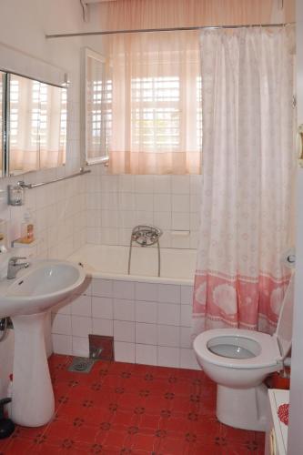 a bathroom with a sink and a toilet and a tub at Family-friendly apartments with swimming pool Orebic, Peljesac - 14644 in Orebić