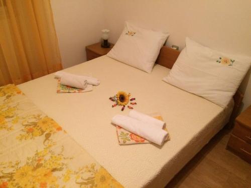 a bed with two towels and flowers on it at Apartments with WiFi Vodnjan, Fazana - 14650 in Vodnjan