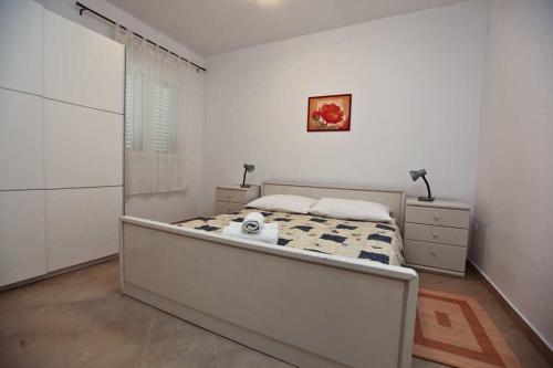 biała sypialnia z łóżkiem i komodą w obiekcie Apartments by the sea Pakostane, Biograd - 14658 w Pakoštane