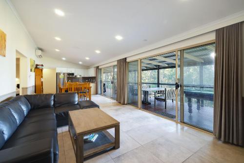 a living room with a black couch and a table at Jindalee Spa Lodge in Vacy