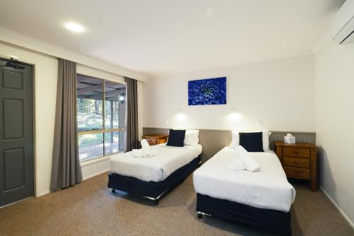 um quarto de hotel com duas camas e uma janela em Jindalee Spa Lodge em Vacy