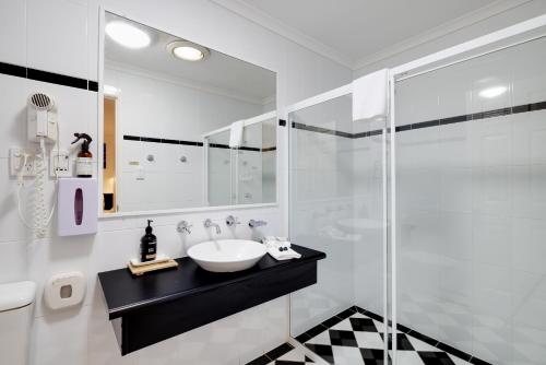 uma casa de banho com um lavatório e uma cabina de duche em vidro. em Jindalee Spa Lodge em Vacy
