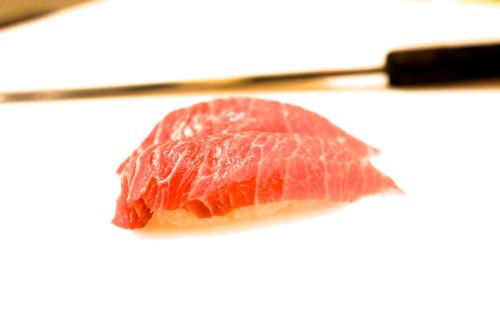 a piece of meat on a plate with a pair of chopsticks at Hotel Pfauen in Umkirch
