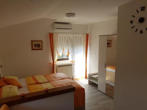 une chambre avec un lit et une horloge au mur dans l'établissement Apartments and rooms with parking space Seliste Dreznicko, Plitvice - 14671, à Rakovica