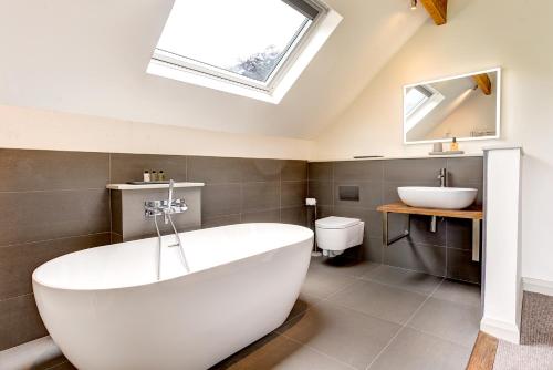 a bathroom with a large white tub and a sink at Lowfield House in Ambleside