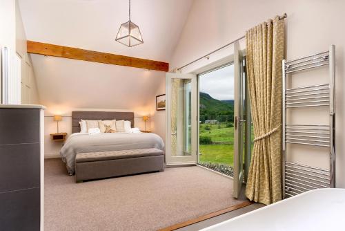 a bedroom with a bed and a large window at Lowfield House in Ambleside