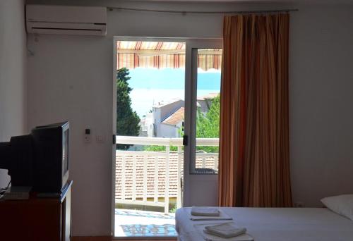 a bedroom with a bed and a door to a balcony at Studio Gradac 13681b in Gradac