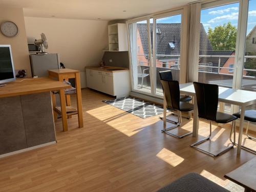 ein Wohnzimmer mit einem Tisch und Stühlen sowie einem großen Fenster in der Unterkunft Wendlers Ferienwohnungen #2 und #3 in Schwaig bei Nürnberg