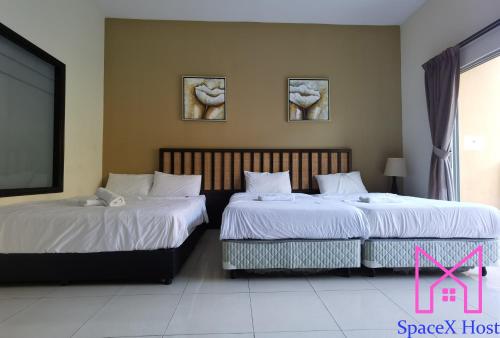 two beds sitting next to each other in a room at Gold Coast Morib Resort in Banting