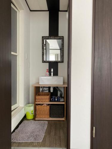 a bathroom with a sink and a mirror at Dining Pension Ezura in Shirahama
