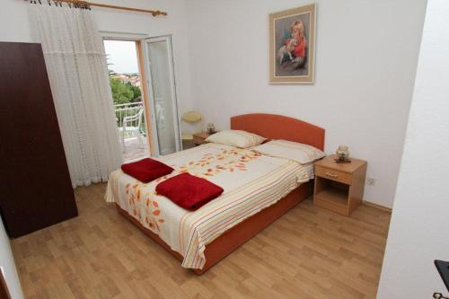 a bedroom with a bed with red pillows on it at Apartments with parking space Sveti Filip i Jakov, Biograd - 14706 in Sveti Filip i Jakov