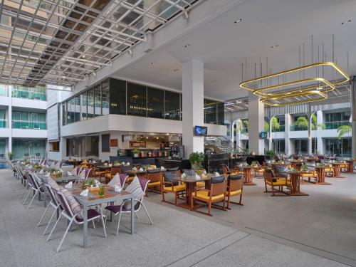 restauracja ze stołami i krzesłami w budynku w obiekcie The Kee Resort & Spa w Patong Beach