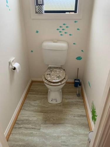a bathroom with a toilet in the corner of a room at Beach Cottage - Port Arthur in Port Arthur