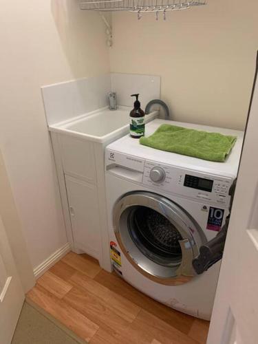 a washing machine with a green towel on top of it at Beach Cottage - Port Arthur in Port Arthur