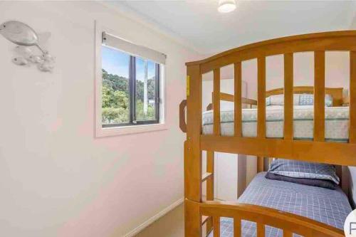 um quarto com um beliche e uma janela em Beach Cottage - Port Arthur em Port Arthur