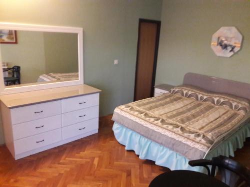 een slaapkamer met een bed en een dressoir met een spiegel bij Apartments by the sea Kozino, Zadar - 14723 in Petrcane
