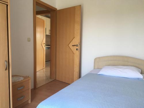 una camera con letto e porta di accesso a una cucina di Apartments with a parking space Zdrelac, Pasman - 14734 a Ždrelac