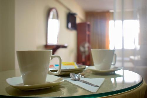 two cups of coffee sitting on a table at Hostal Solari in Trujillo