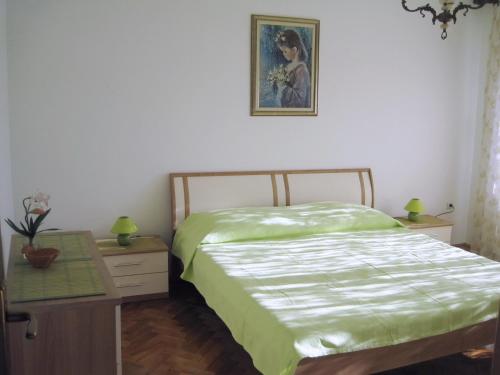 a bedroom with a bed and a table and a picture at Apartments with a parking space Zadar - Diklo, Zadar - 14750 in Zadar