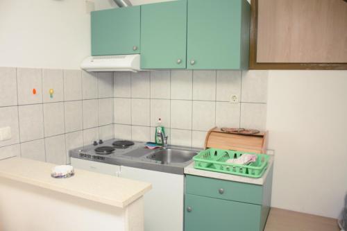 kuchnia z niebieskimi szafkami i zlewem w obiekcie Apartments and rooms by the sea Lumbarda, Korcula - 14647 w mieście Lumbarda