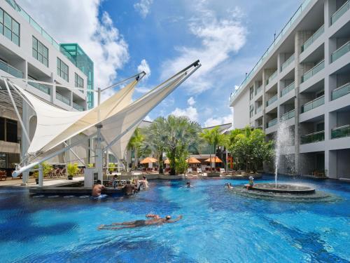 uma piscina num hotel com uma fonte em The Kee Resort & Spa em Patong Beach