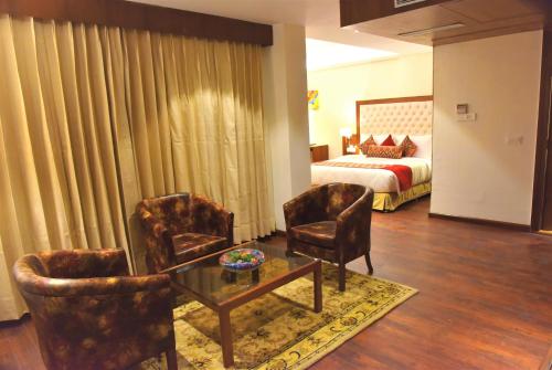 a living room with two chairs and a bed at Royale Retreat Hotel & Spa Near Mall Road in Shimla