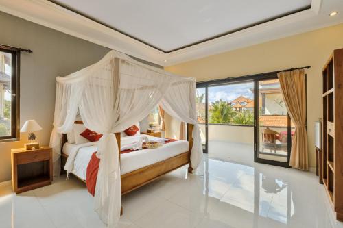 ein Schlafzimmer mit einem Himmelbett und einem großen Fenster in der Unterkunft Gora House Bali in Ubud