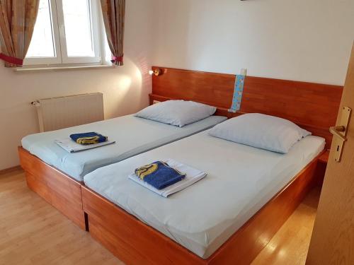 a pair of beds in a bedroom with two towels at Apartments and rooms by the sea Stanici, Omis - 14782 in Omiš