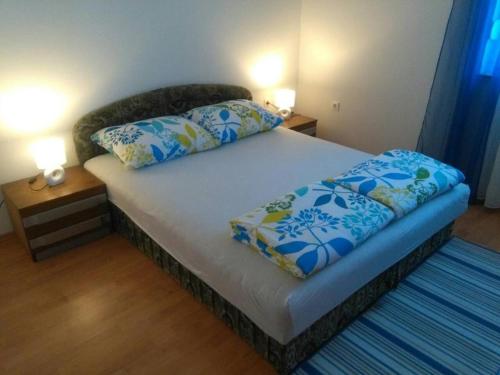 a bed with two pillows on it in a room at Family friendly apartments with a swimming pool Tribalj, Crikvenica - 14789 in Tribalj