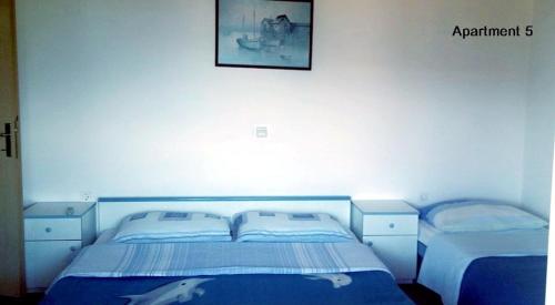 a bedroom with two beds and a picture on the wall at Apartments with WiFi Lopar, Rab - 14804 in Lopar