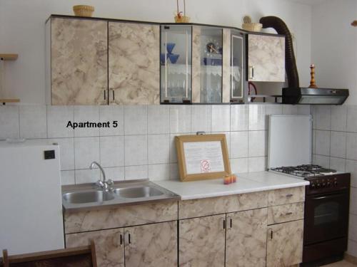 a kitchen with a sink and a stove at Apartments with WiFi Lopar, Rab - 14804 in Lopar