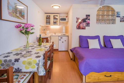 a bedroom with a bed and a table with flowers on it at Apartments by the sea Vrbnik, Krk - 14806 in Vrbnik