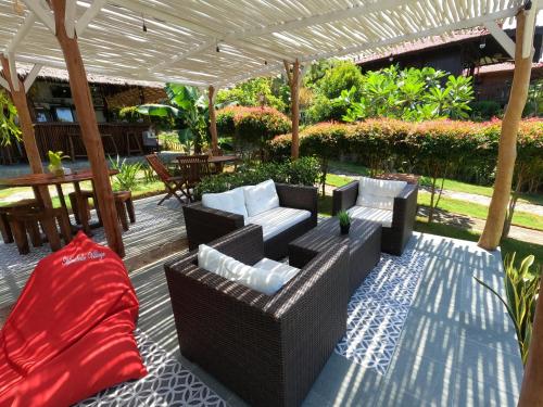 a patio with a couch and chairs under a pergola at Mirabelle Joglo Village in Karimunjawa
