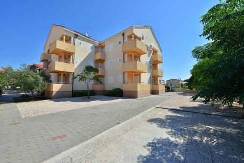 ein Apartmenthaus in einer Kopfsteinpflasterstraße in der Unterkunft Apartments by the sea Privlaka, Zadar - 14816 in Privlaka