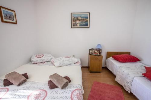a room with two twin beds and a tv at Apartments by the sea Krilo Jesenice, Omis - 14823 in Krilo