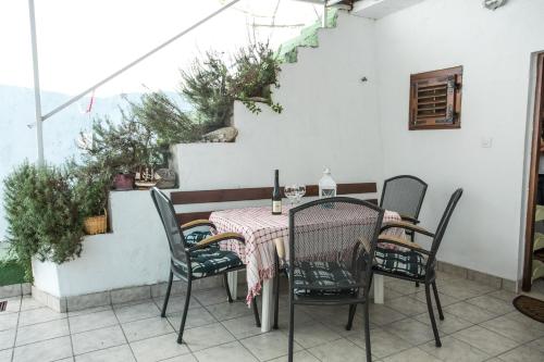 a table and chairs on a patio with stairs at Apartments by the sea Krilo Jesenice, Omis - 14823 in Krilo