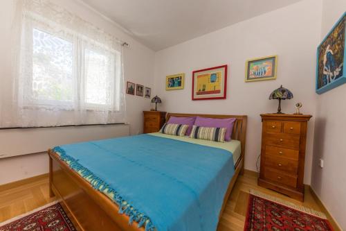 a bedroom with a bed and a dresser and a window at Apartment Arbanija 14825b in Trogir